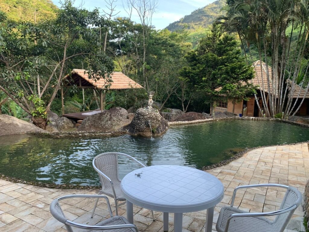 Área externa com gramado e mesas na Flor de Maria Retiros