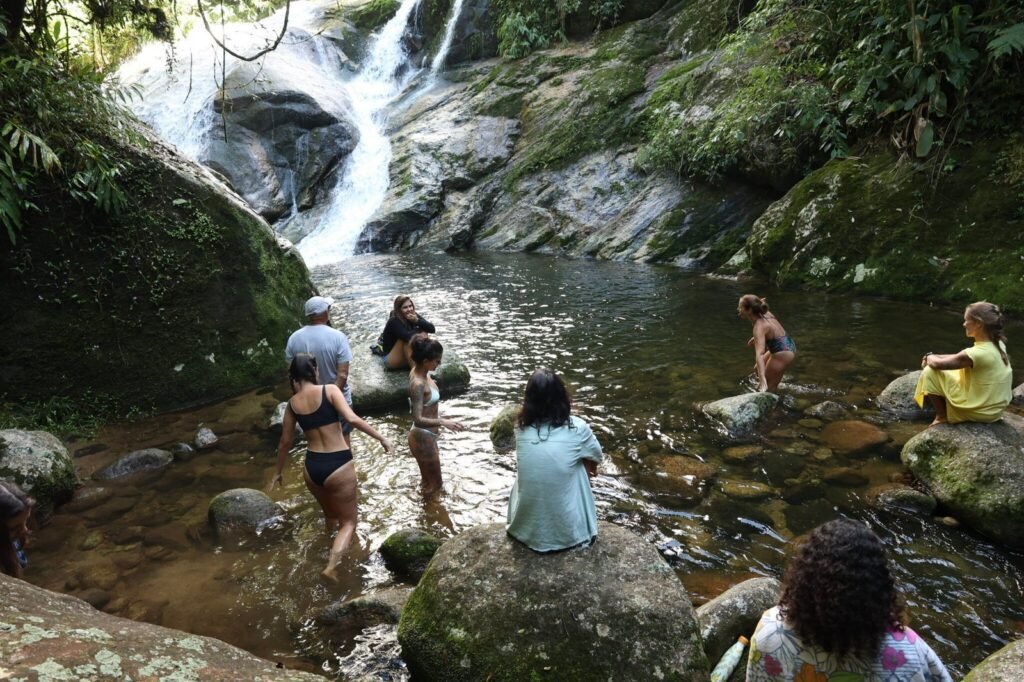 Grupo em banho de cachoeira durante retiro na Mata Atlântica, Sana RJ