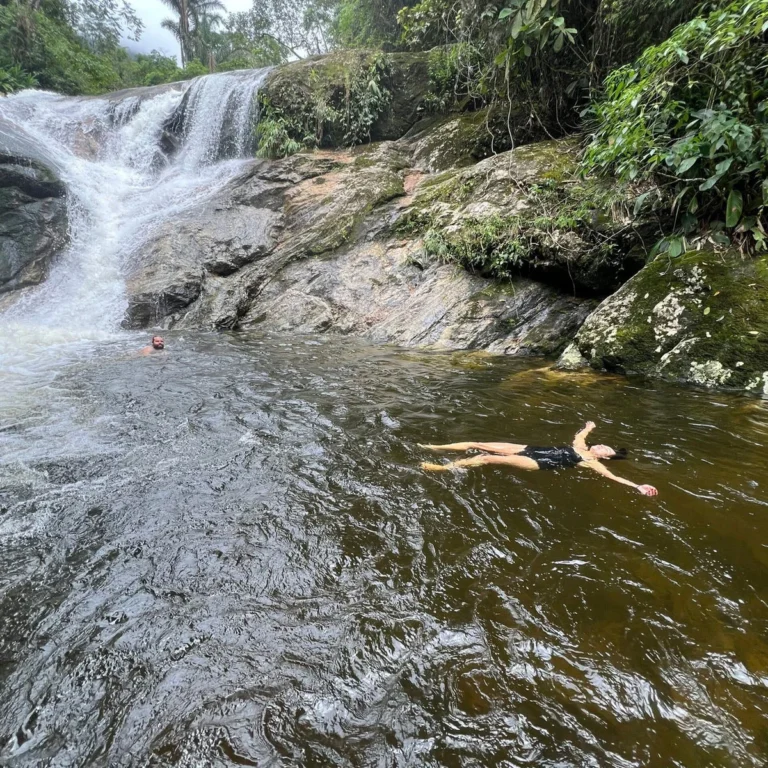 Pessoa boiando no rio entre cachoeiras na Mata Atlântica do Sana